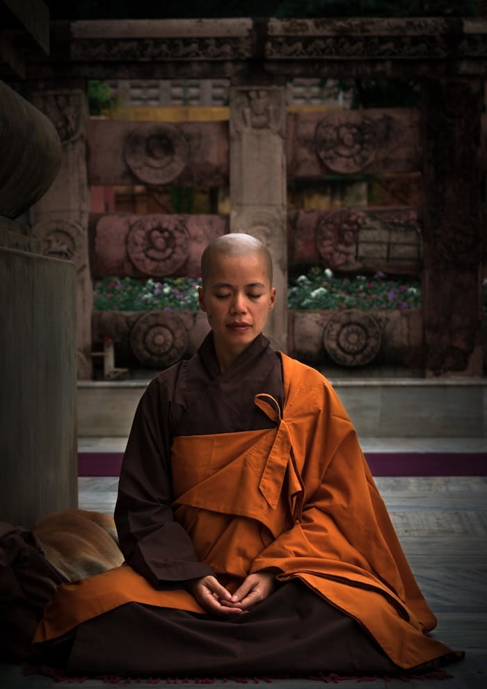 Services A monk meditating in a temple wearing traditional robes, embodying tranquility and spirituality.